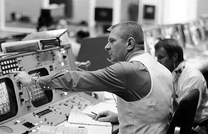 Date Created: 1972-04-16 Flight director Eugene F. Kranz is seated at his console in the mission operations control room in the Manned Spacecraft Center's Mission Control Center on the morning of the launch of the Apollo 16 lunar landing mission. Partially visible in the background is flight director Gerald D. Griffin.