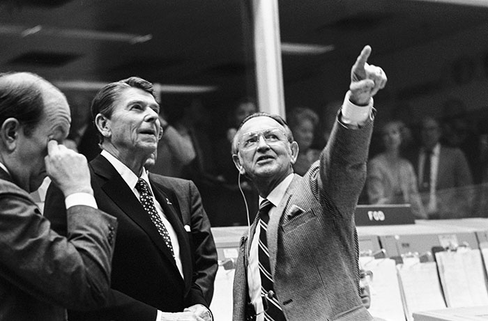 Date Created: 1981-11-13 President Ronald Reagan is briefed by JSC Director Christopher C. Kraft Jr., who points toward the orbiter spotter on the projection plotter in the front of the mission operations control room in the Johnson Space Center's Mission Control Center. This picture was taken just prior to a space-to-ground conversation between STS-2 crew members Joe H. Engle and Richard H. Truly, who were orbiting Earth in the space shuttle Columbia.