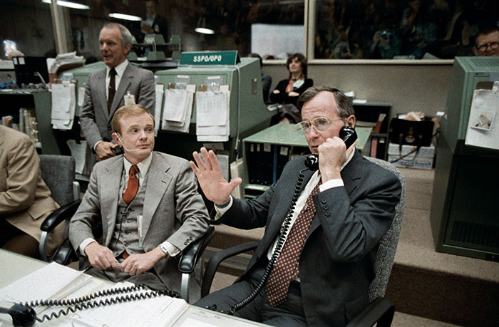 Vice President George Bush talks to the Earth-orbiting STS-6 astronauts from the spacecraft communicators; (CAPCOM) console in the mission operations control room (MOCR) of the Johnson Space Center’s mission control center. Astronaut Roy D. Bridges, is one of the CAPCOM personnel on duty. JSC Director Gerald D. Griffin, left, watches a large monitor (out of frame) on which the TV scene of the four-member Challenger crew is visible.