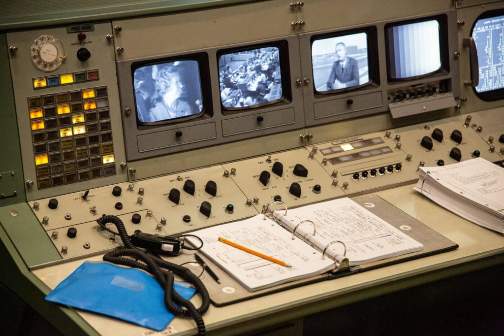 A visit to the restored Apollo Mission Control Center is a must see at Space Center Houston. Inside the room, furnishings on the consoles, flight control manuals, ashtrays, coffee cups and headsets, depict an accurate look of the iconic room based on the Apollo era.