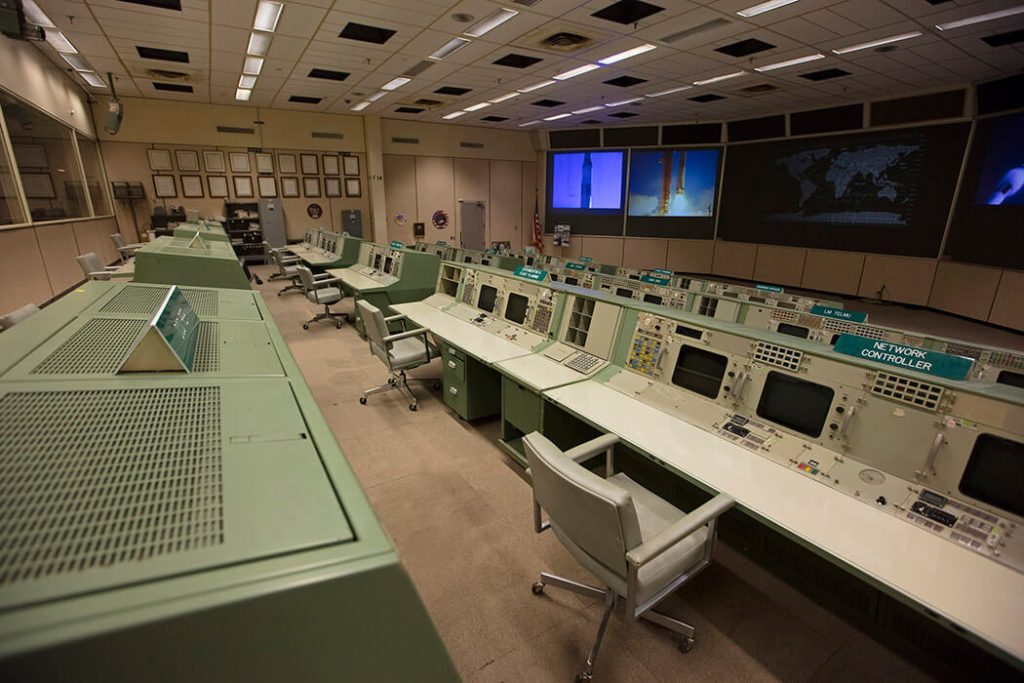 An overall view of the consoles used in Historic Mission Control. The consoles used by multiple flight directors contained no computing elements - they displayed only different information channels coming in from the mainframe. Of the hundreds of buttons, monitors and controls located at these flight controller stations, many have gone missing or have become faded after decades of use.