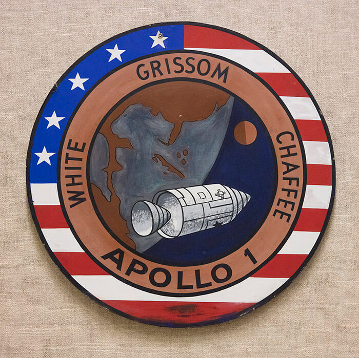 Historic Mission Control is decorated with emblems of past missions such as this one in remembrance of Apollo 1. The Apollo 1 crew, Gus Grissom, Ed White and Roger Chaffee, died in a cabin fire during a launch rehearsal test in 1967.